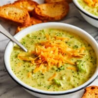 A creamy broccoli cheddar soup, topped with cheddar cheese and seasoned with salt and pepper.