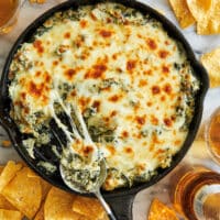A hot and cheesy spinach and artichoke dip served with tortilla chips.