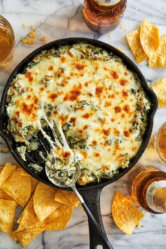 A hot and cheesy spinach and artichoke dip served with tortilla chips.