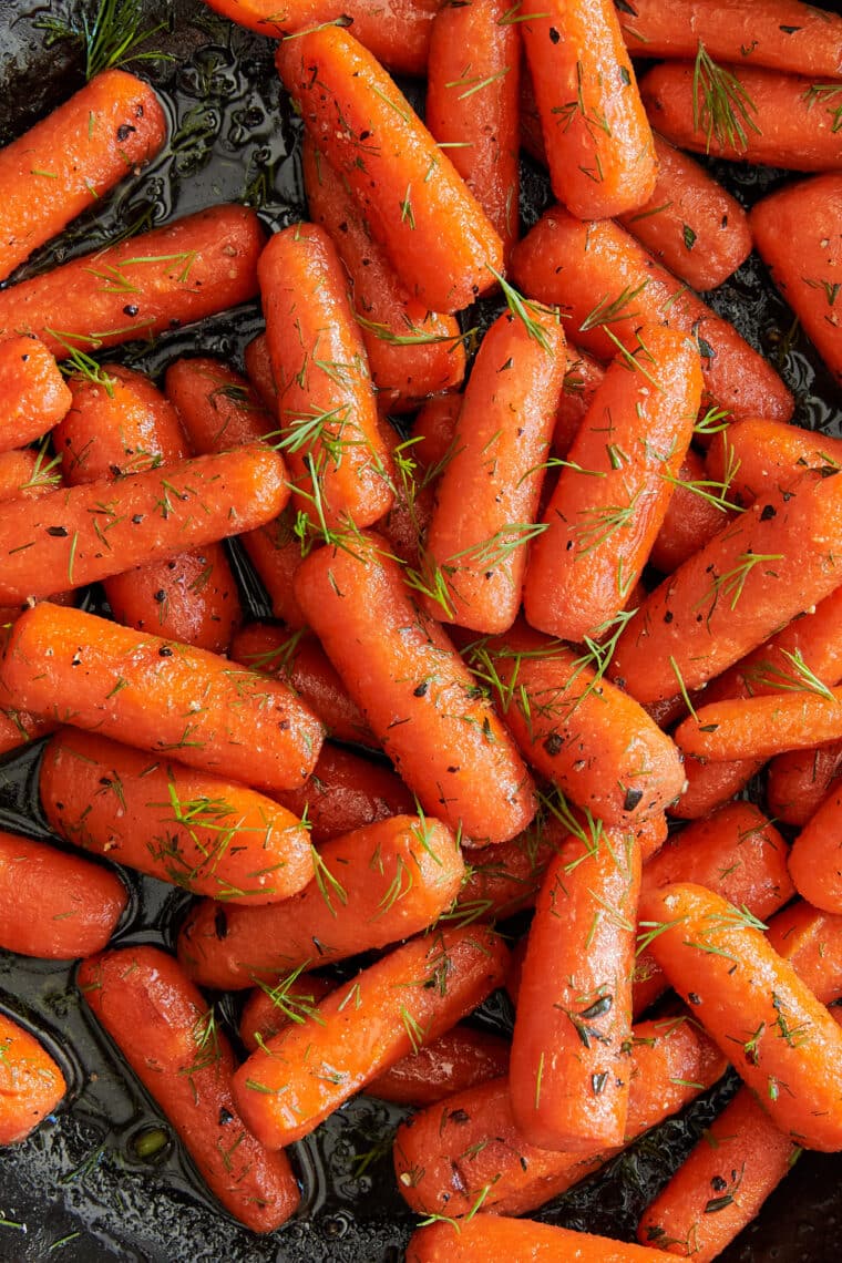 Honey Glazed Baby Carrots - The sweet + sticky honey glaze makes these baby carrots completely irresistible in this easy 15-minute side dish!