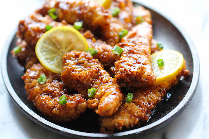 Crisp Asian Lemon chicken tenders drizzled with lemon glaze and served with lemon slices.